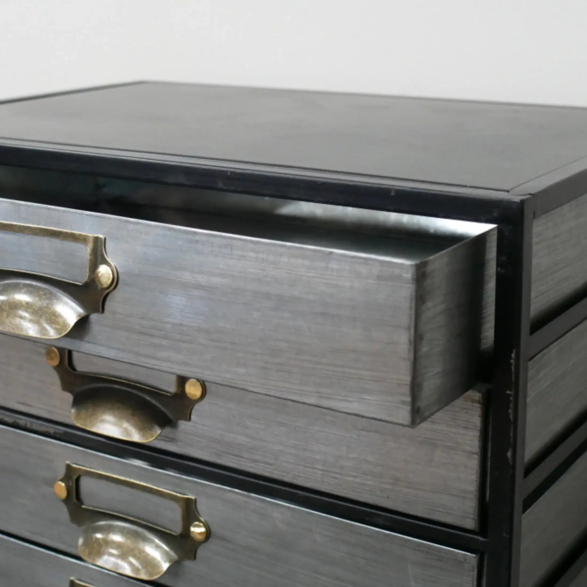 Gray wooden dresser with brass handles on a white background