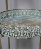 Decorative metal table with intricate patterns on a plain background