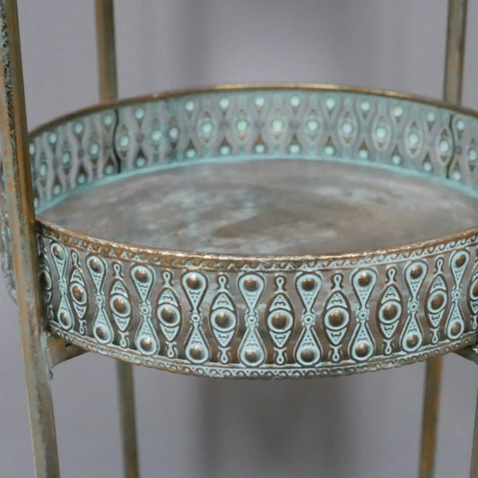 Decorative metal table with intricate patterns on a plain background