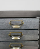 Metallic drawer unit with brass handles on a gray background