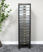 Tall gray dresser with multiple drawers against a white wall.