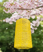 Yellow lace curtain hanging in front of cherry blossoms