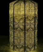 Decorative lantern with intricate cut-out pattern glowing in the dark