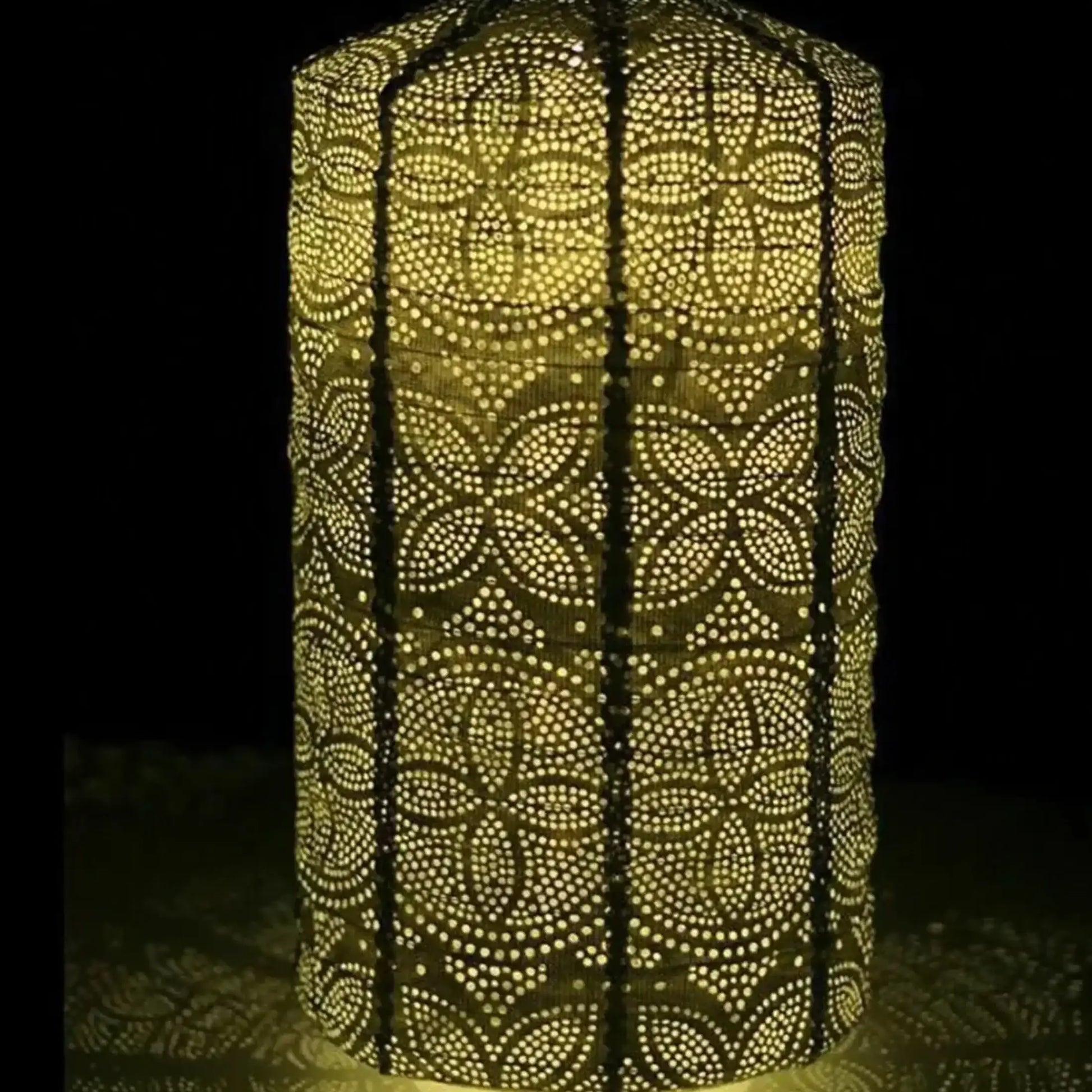 Decorative lantern with intricate cut-out pattern glowing in the dark