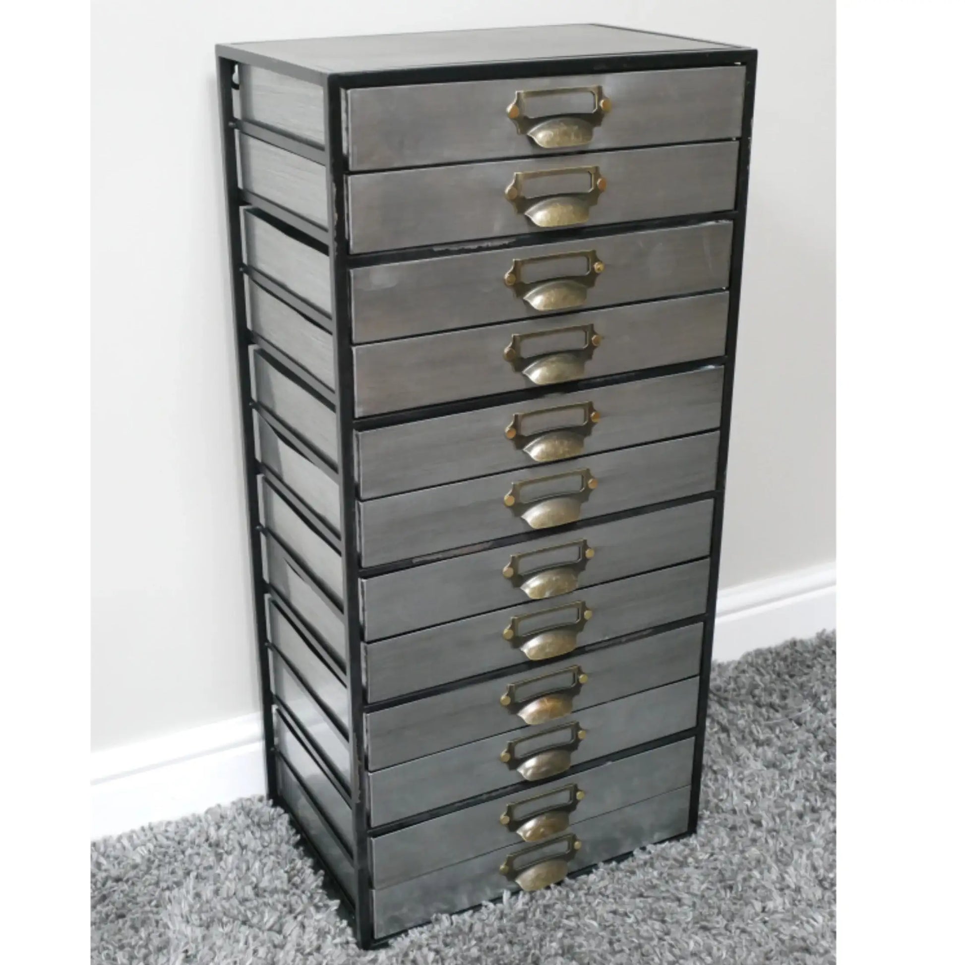 Tall metal drawer unit with multiple drawers on a gray carpet