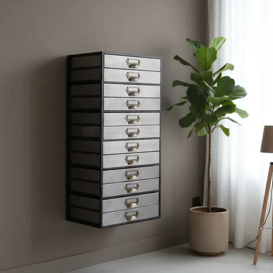 Tall mirrored drawer unit against a wall with a plant next to it.