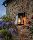 Black outdoor wall light fixture on a wooden wall with blurred natural background