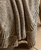 Close-up of a textured brown blanket on a wooden surface