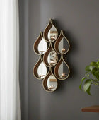 Decorative metal wall art with wavy, teardrop shapes on a white background