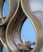 Decorative metal wall art with intricate patterns on a textured wall background