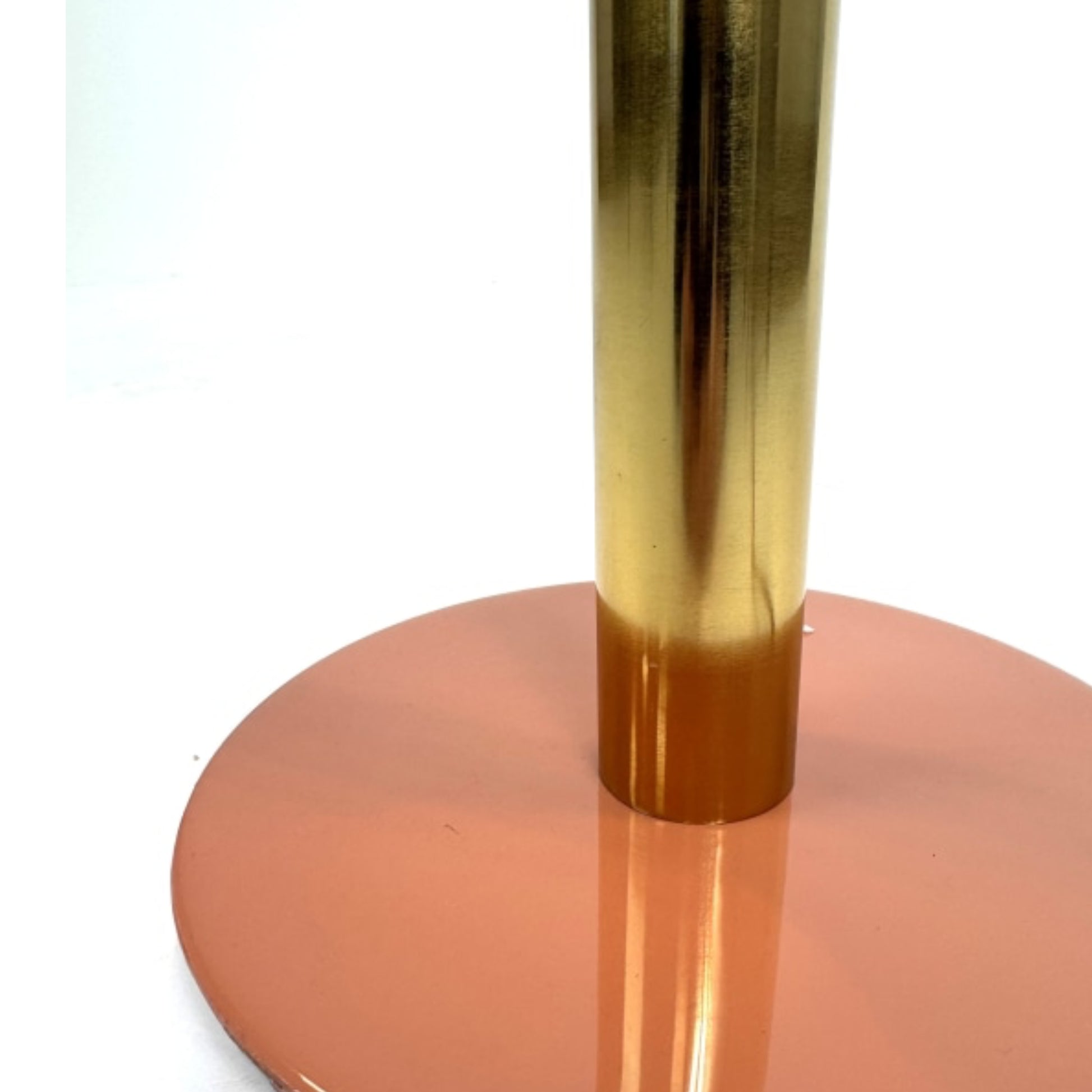 Gold cylindrical object on a pink circular base against a white background