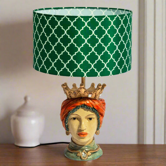 Decorative lamp with a green patterned shade on a wooden surface.