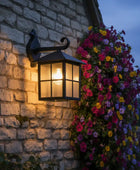 Decorative outdoor light fixture on a stone wall with flowers.