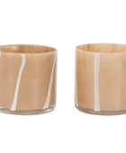 Two glass tumblers with beige bodies and white stripes on a white background