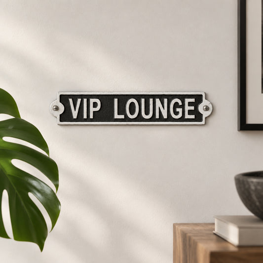 A rectangular black and white metal sign reading 'VIP LOUNGE' mounted on a beige paneled wall.