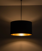 Black pendant light with a gold interior on a dark background