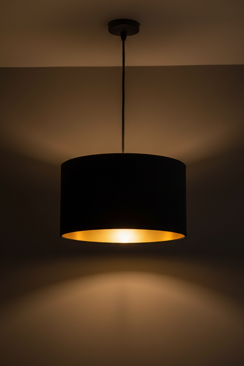 Black pendant light with a gold interior on a dark background