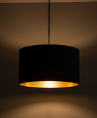 Black pendant lamp with a gold interior on a dark background