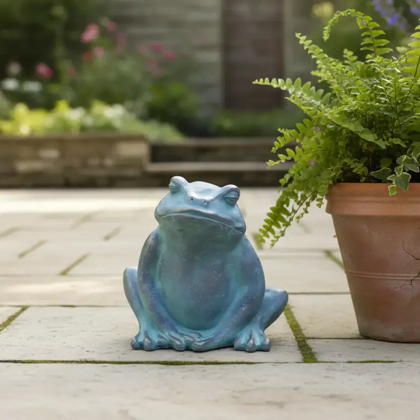 Blue frog statue on a patio with potted plants in the background