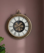 Decorative wall clock with intricate design on a pink wall