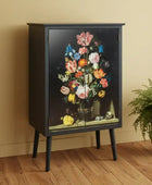 Black cabinet with floral design on a beige wall