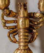 Gold lobster figurine on a white background