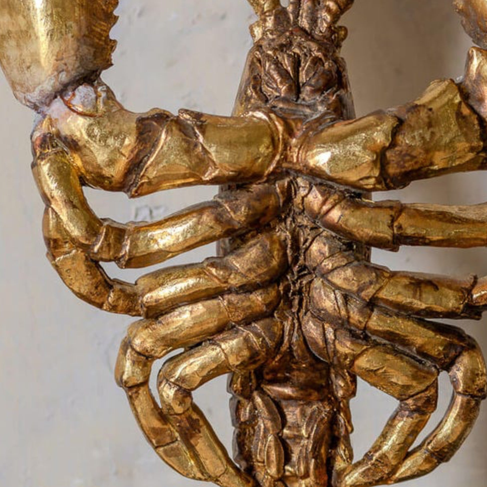 Close-up of a gold spider-like decorative object on a white background