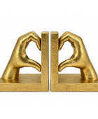 A pair of gold-finished bookends shaped like hands forming a heart shape, set against a plain white background.