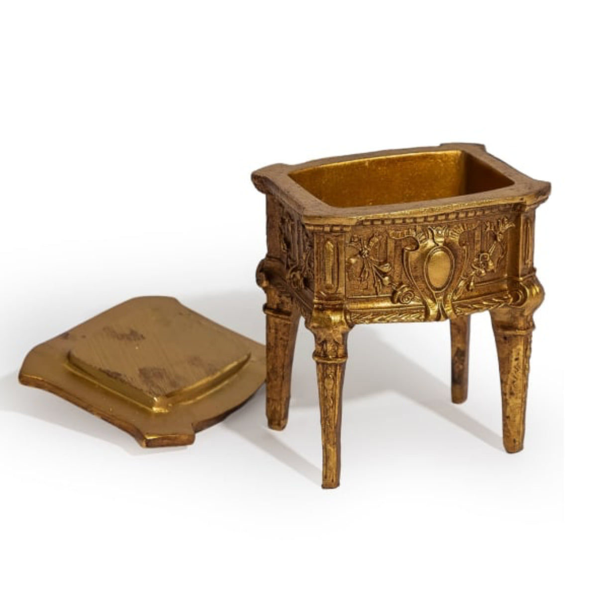 An ornate miniature gold-toned metal candelabra or decorative pedestal with a matching lid placed beside it, photographed on a clean white background.