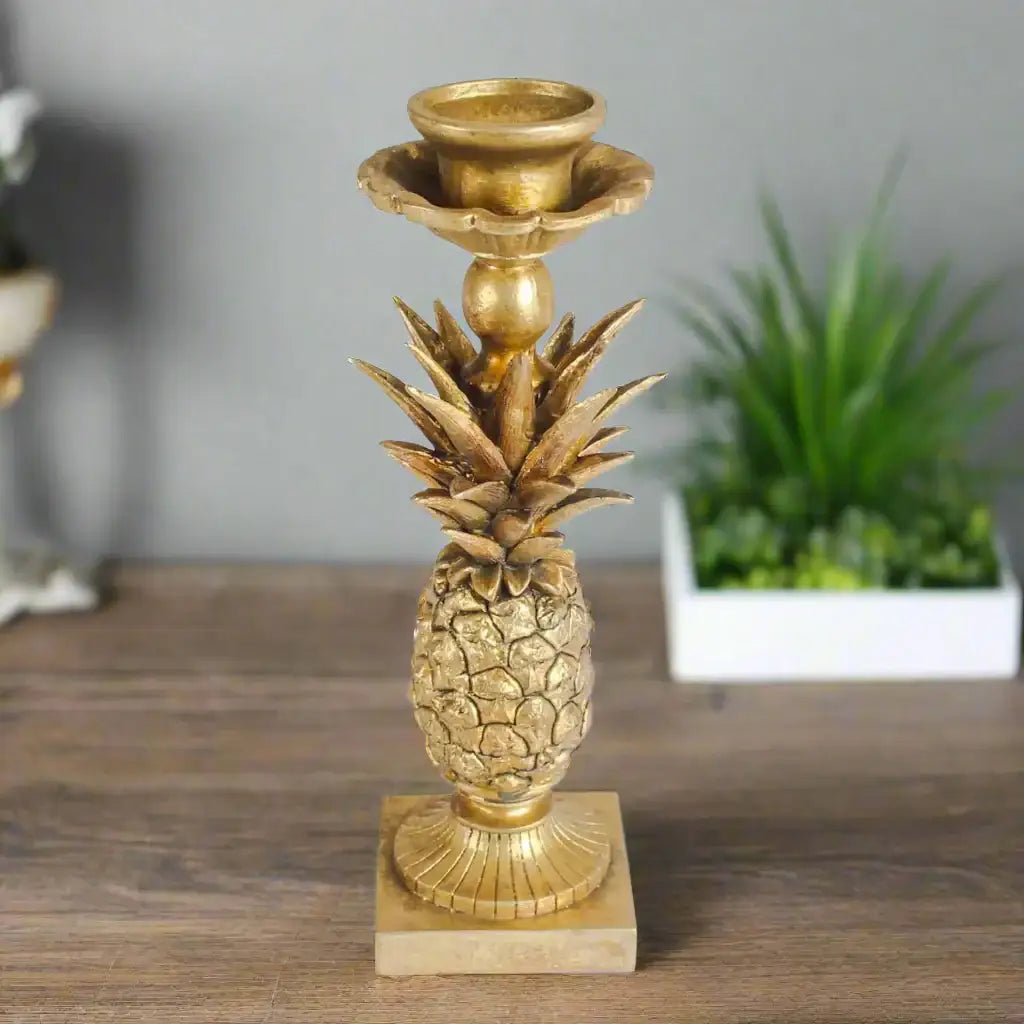 Gold pineapple-shaped candle holder on a white background