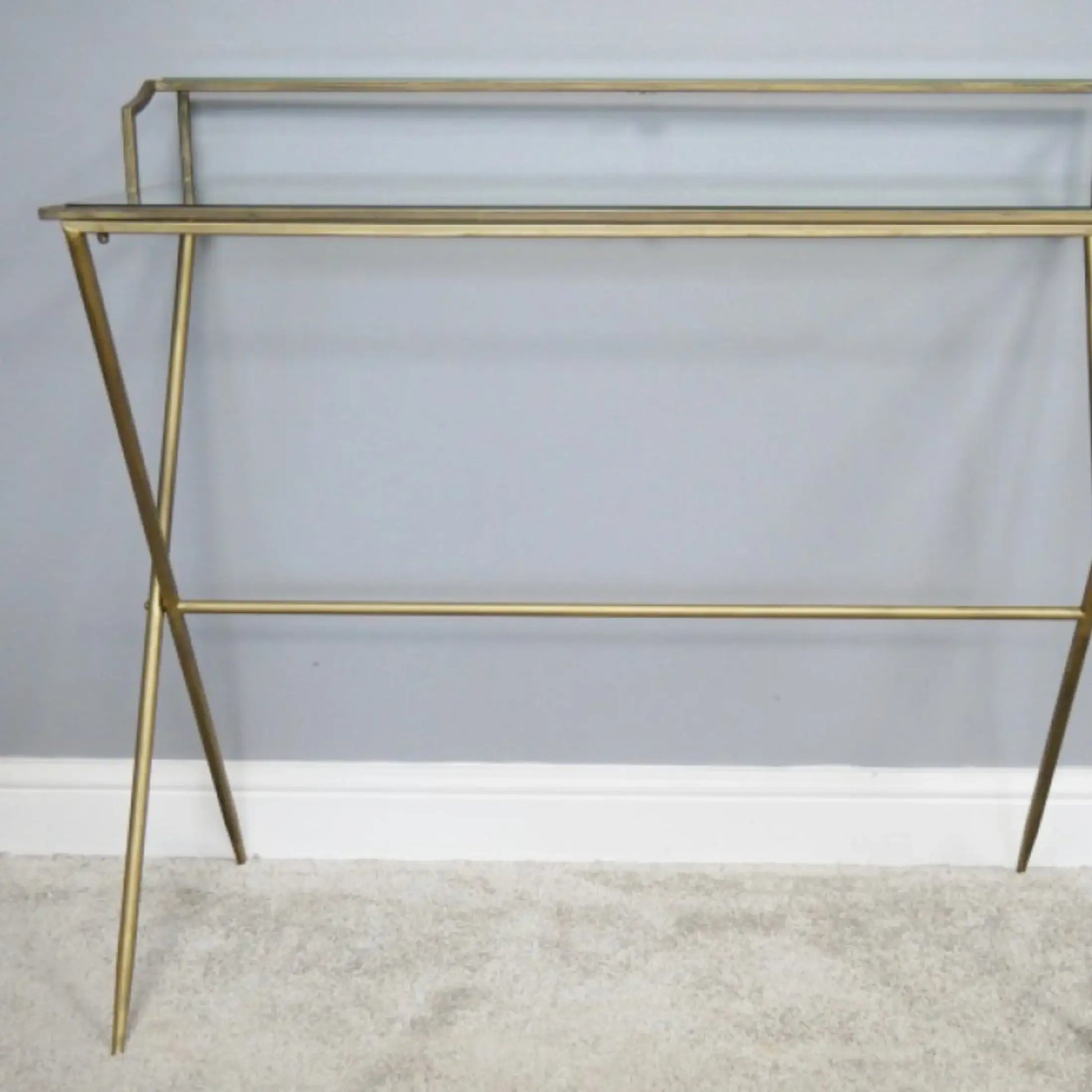 Gold metal shelf against a gray wall