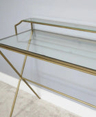 Glass console table with gold metal legs on a neutral background