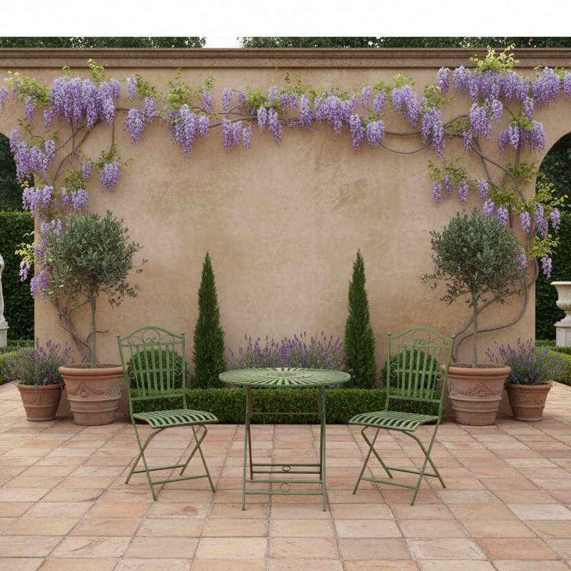 Outdoor patio setting with green chairs and table against a wall with wisteria