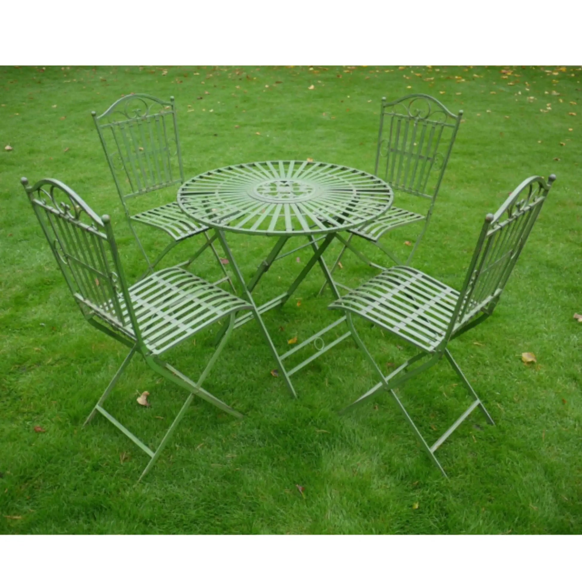 Green metal garden table and chairs set on grass