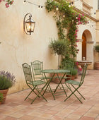 Outdoor patio with green metal furniture, potted plants, and string lights.