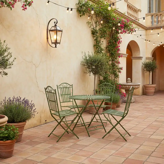 Outdoor patio with green metal furniture, potted plants, and string lights.