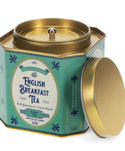 A hexagonal metal tea tin with a gold lid and teal label, shown open with the lid leaning against it on a white background. The label reads 'English Breakfast Tea' and 'Black Tea'.