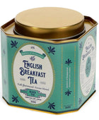 A hexagonal metal tin of English Breakfast Tea from Battle's of Hampstead, featuring a teal-green body with navy blue botanical illustrations, a white central label, and a metallic gold lid.