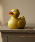 Yellow rubber duck on a wooden surface with a neutral background