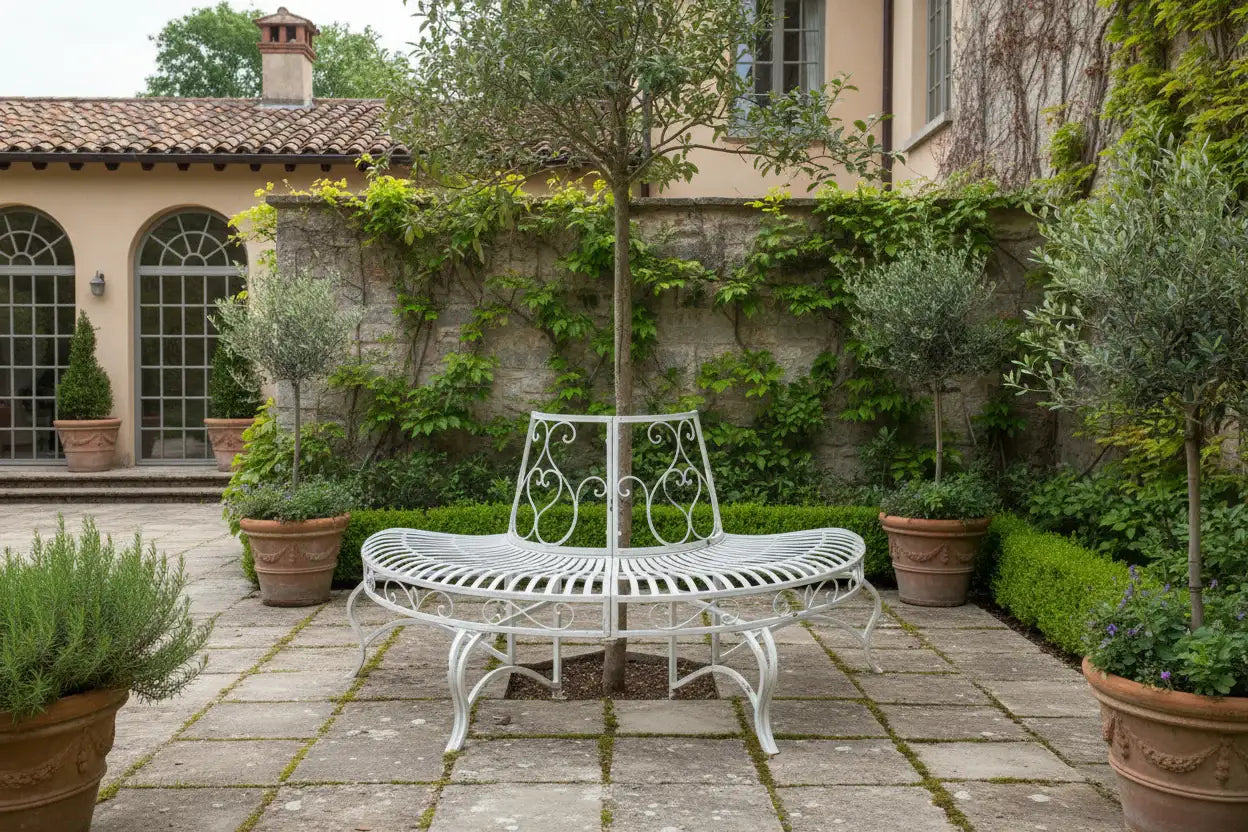 White garden bench and table set in a patio area with potted plants and a stone wall.