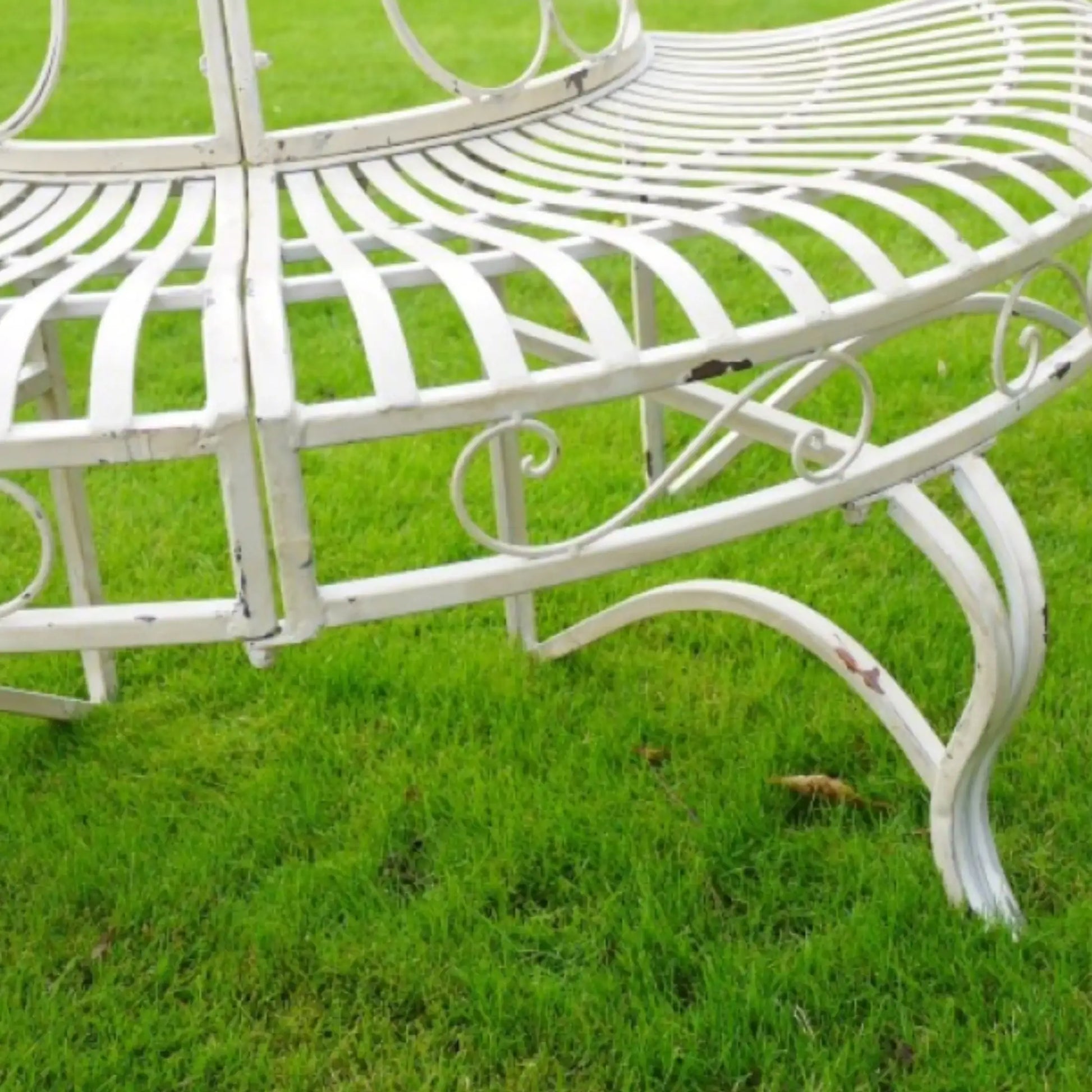 White metal bench on a grassy background