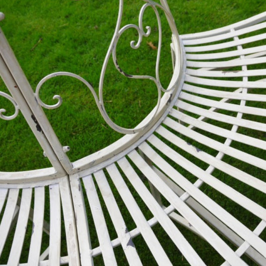 White metal garden bench with decorative backrest on a grassy background