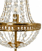 Close-up of a gold-finished chandelier with clear crystal bead strands and a visible light bulb, shown against a plain white background.