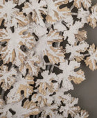 Close-up of decorative snowflake cutouts with gold and white details on a dark background