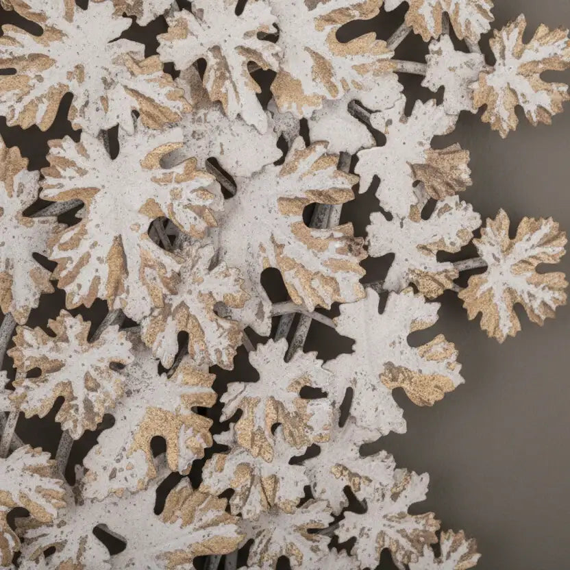 Close-up of decorative snowflake cutouts with gold and white details on a dark background