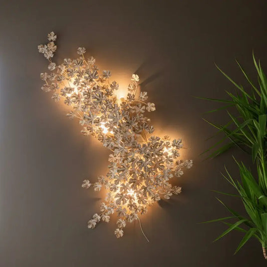 Decorative wall light fixture with floral design on a wooden panel background