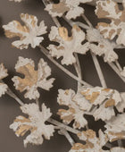 Decorative metal wall art with leaf patterns on a brown background