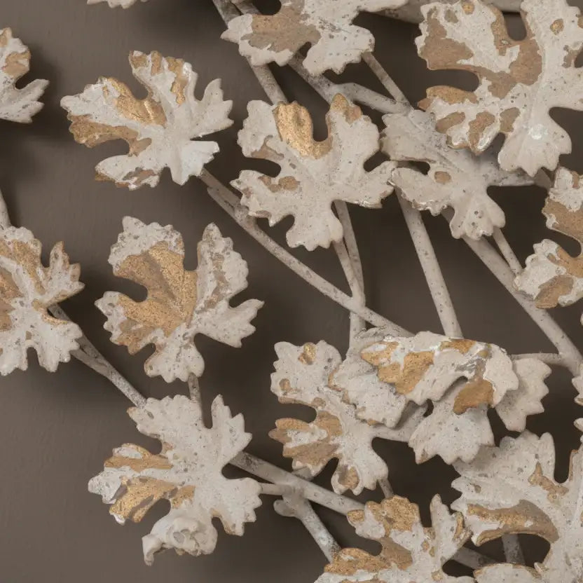 Decorative metal wall art with leaf patterns on a brown background