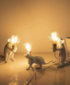 Three mouse-shaped lamps with light bulbs on a warm-toned background