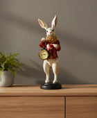 Decorative rabbit figurine with a clock on a wooden surface next to a plant.